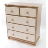 A pine chest, of two over three drawers, painted beige and white, raised on turned feet, 105cm high,