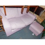 A two seater sofa, upholstered in lavender coloured fabric, together with a matching foot stool. (