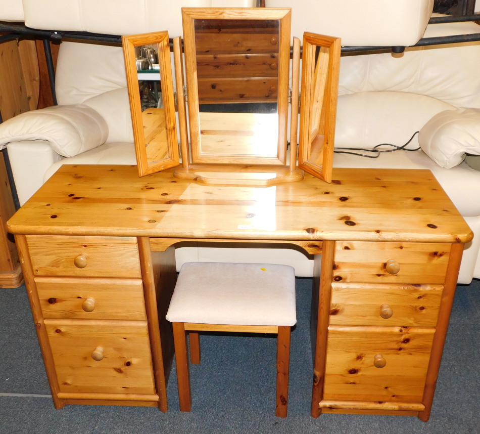 A pine dressing table, of six drawers, 75cm high, 138cm wide, 49cm deep., with tryptic mirror and