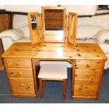 A pine dressing table, of six drawers, 75cm high, 138cm wide, 49cm deep., with tryptic mirror and