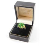 An emerald green paste set flower head ring, in white and yellow metal, boxed, size R.