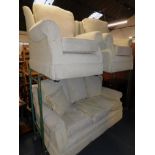 A three seater sofa and two armchairs, upholstered in cream chenille fabric. (3)