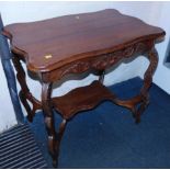 An early 20thC walnut two tier occasional table, with carved apron and legs, 71cm high, 77cm wide,