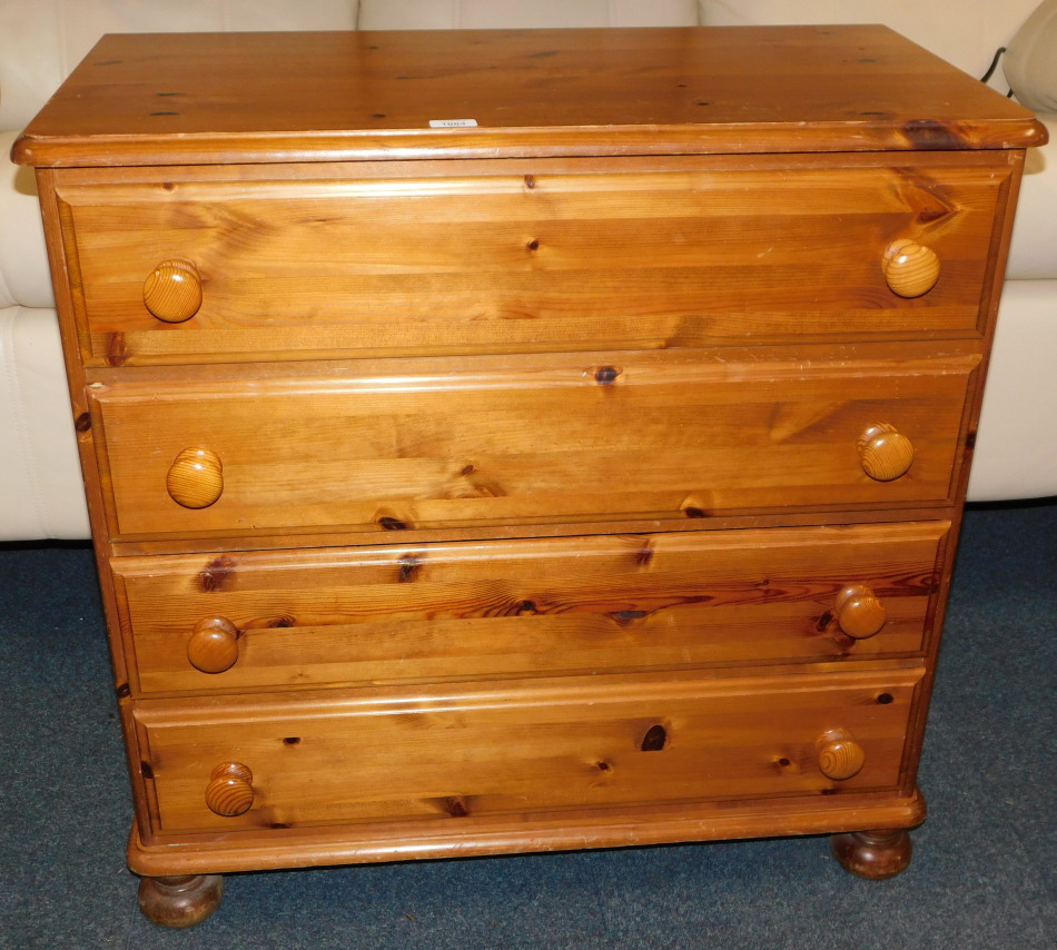 A pine chest, of four long drawers, raised on bun feet, 85cm high, 83cm wide, 43cm deep.