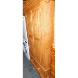 A waxed pine double wardrobe, with two doors above false single drawer, 196cm high, 101cm wide, 60cm