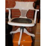 An early 20thC wooden framed desk chair, painted white, with upholstered seat.