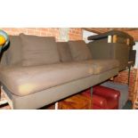 A brown fabric U shaped sofa, raised on square legs.