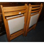 A set of four mid 20thC beech framed folding chairs, with cream vinyl seats.