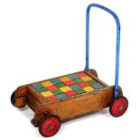 A Tri-ang baby walker with wooden building blocks.