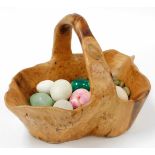 A carved elm basket and contents of marble eggs and pebbles.