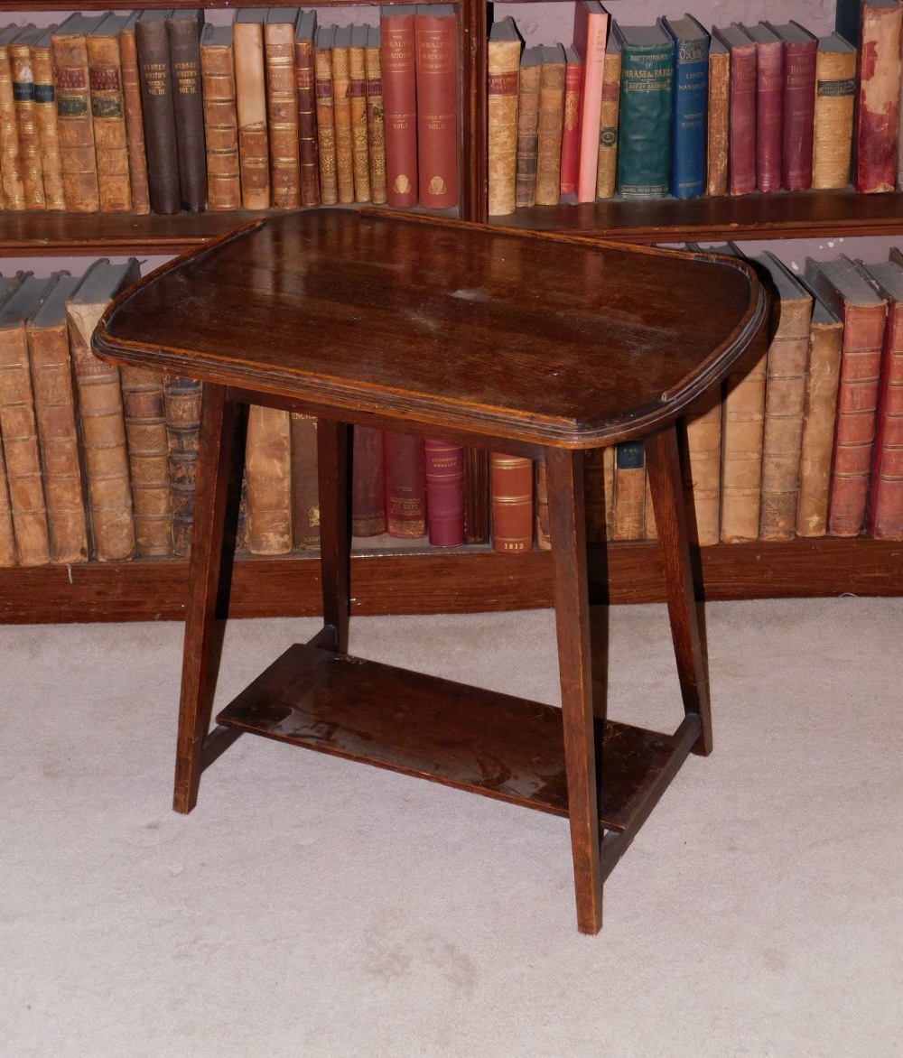 An early 20thC oak occasional table, the top with a raised gallery, on square tapering legs, with