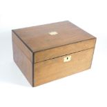 A Victorian walnut workbox, with inset corners, a blank cartouche to the lid with a silk lined