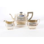 A George V three piece silver tea set, of Georgian design with swollen bodies and reeded bands, on