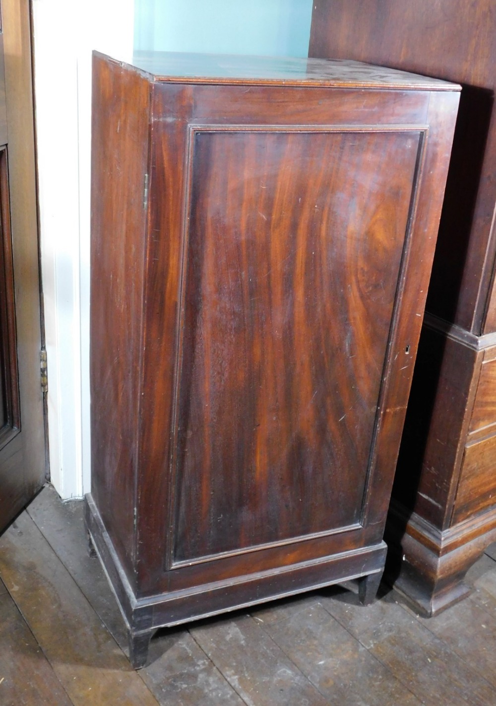 An early 19thC mahogany folio cabinet, the top with a moulded edge and a single panelled door