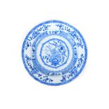 An 18thC Chinese blue and white plate, decorated with a stylized vase of flowers and cell border,