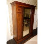 A late Victorian mahogany wardrobe, with a moulded cornice above a single mirrored door flanked by