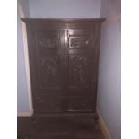 A 17thC and later carved oak two-door cupboard, with moulded cornice, two carved panel doors