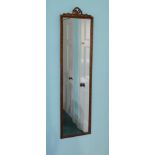 A rectangular gilt wall mirror, the frame decorated with ribbons, etc., 134cm high, 34cm wide.