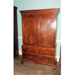 A George III mahogany clothes press, the top with a moulded cornice carved with paterae flutes and