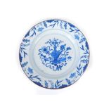 A Chinese blue and white plate, decorated with precious objects within a border of vines and bamboo,