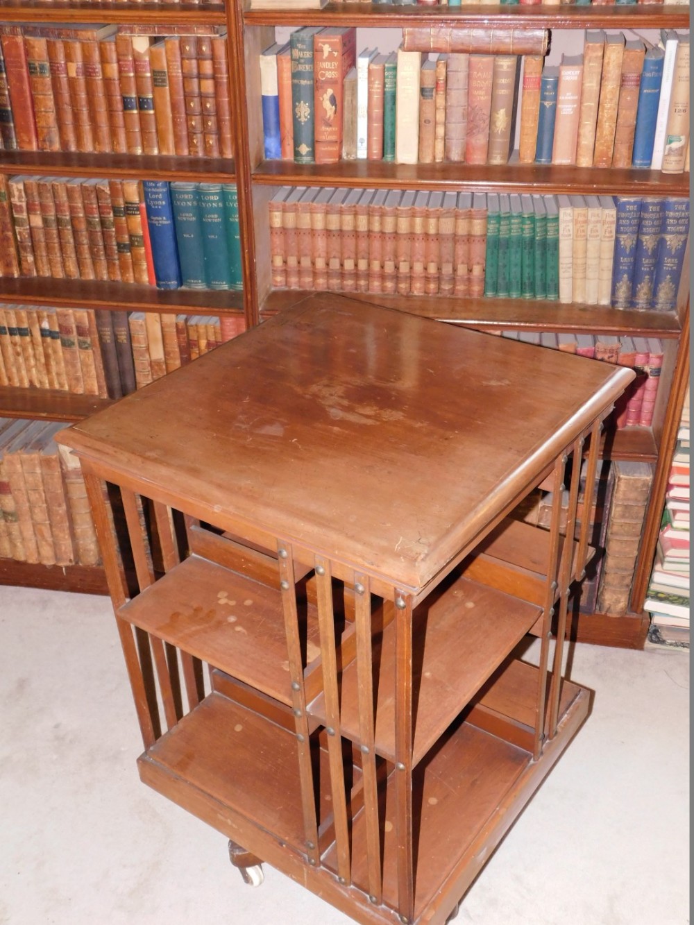 A Edwardian mahogany revolving bookcase, with slatted supports on X shaped base with ceramic - Image 2 of 3