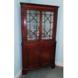 An early 19thC mahogany freestanding corner cabinet, with a moulded cornice and an ebony boxwood