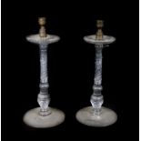 A pair of early 19thC glass candlesticks, with brass sconces and broad cut drip pans, supported on