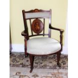 An Edwardian mahogany and marquetry open armchair, with a padded back and seat inlaid with musical