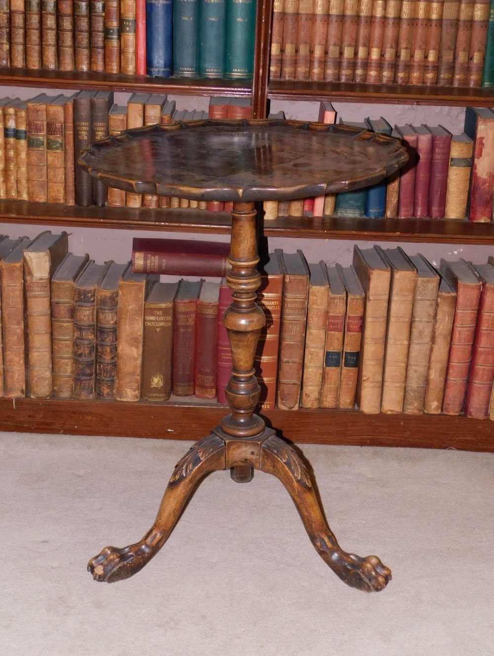 A mahogany occasional table, the circular dished pie crust top, on a turned column and tripod