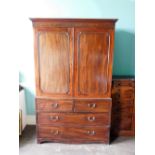 An early 19thC mahogany clothes press, the top with a moulded cornice above two panelled doors