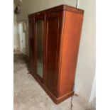 A Victorian mahogany triple wardrobe, with centred mirror door and fitted interior, 202cm high, 185
