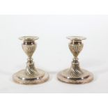 A pair of silver plated dwarf candlesticks, of classical urn shaped whorl fluted design, marked H