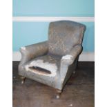 A late 19thC/early 20thC deep armchair, upholstered in gold and blue fabric on beech turned tapering