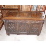 A late 17thC oak coffer, with a triple plank hinged top, the front carved with lozenges, scrolls and