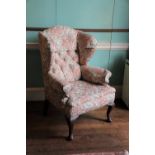 A mahogany wingback armchair in mid 18thC style, upholstered in floral fabric on cabriole legs