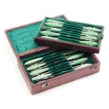 A set of eighteen late Victorian steel pickle forks, with turned green handles, in a fitted plush