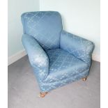 An Edwardian armchair, re-upholstered in patterned fabric, on bun feet with later castors.