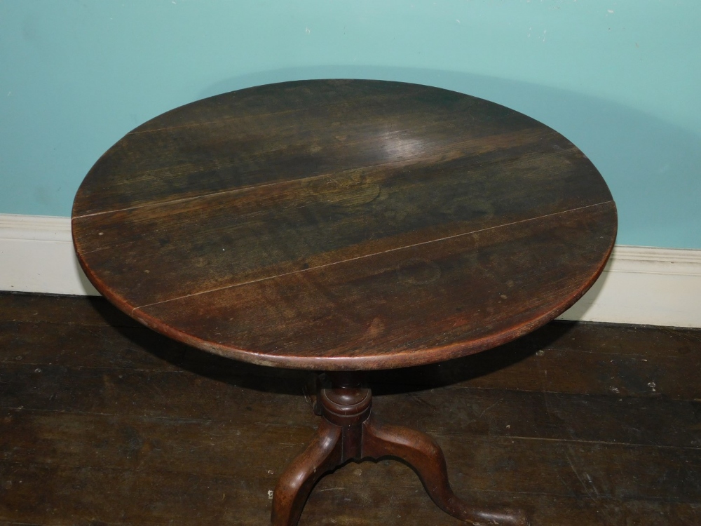 An early 19thC oak occasional table, the circular planked tilt top on a turned column and a tripod - Image 2 of 2