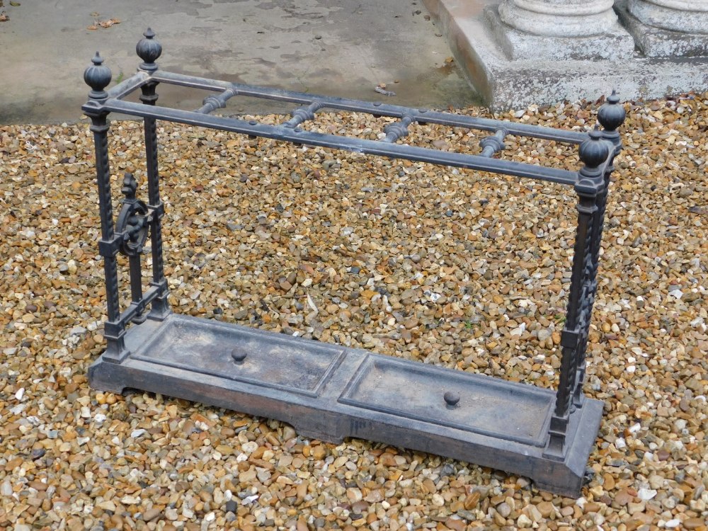 A Victorian cast iron umbrella stand, with five divisions, on spiral end supports, headed by