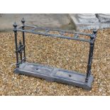 A Victorian cast iron umbrella stand, with five divisions, on spiral end supports, headed by