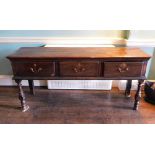 An early 18thC oak dresser base, the top with a moulded edge above three frieze drawers each with