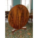 A William IV rosewood breakfast table. the circular top on a turned and lotus carved column, with