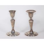 A pair of Victorian silver Adam style candlesticks, with fluted and shaped holders and beaded