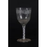 A 18thC glass wine goblet, with semi fluted bowl engraved with a band of fruiting vine decoration,