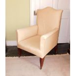 An Edwardian mahogany armchair, upholstered in green calico fabric, on square tapering legs with