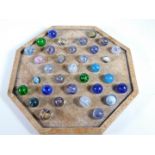 An octagonal solitaire board and a collection of marbles.