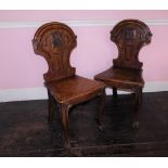 A pair Victorian oak hall chairs, the shield shaped back with carved Pegasus crest, the solid
