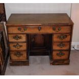 A George III mahogany kneehole desk, the top with a moulded edge above a frieze drawer and flanked