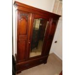 A late Victorian walnut wardrobe, with a moulded cornice above a bevelled mirrored door over