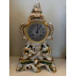 A 19thC French porcelain mantel clock, rococo scroll design with rosebud and foliate finial, with